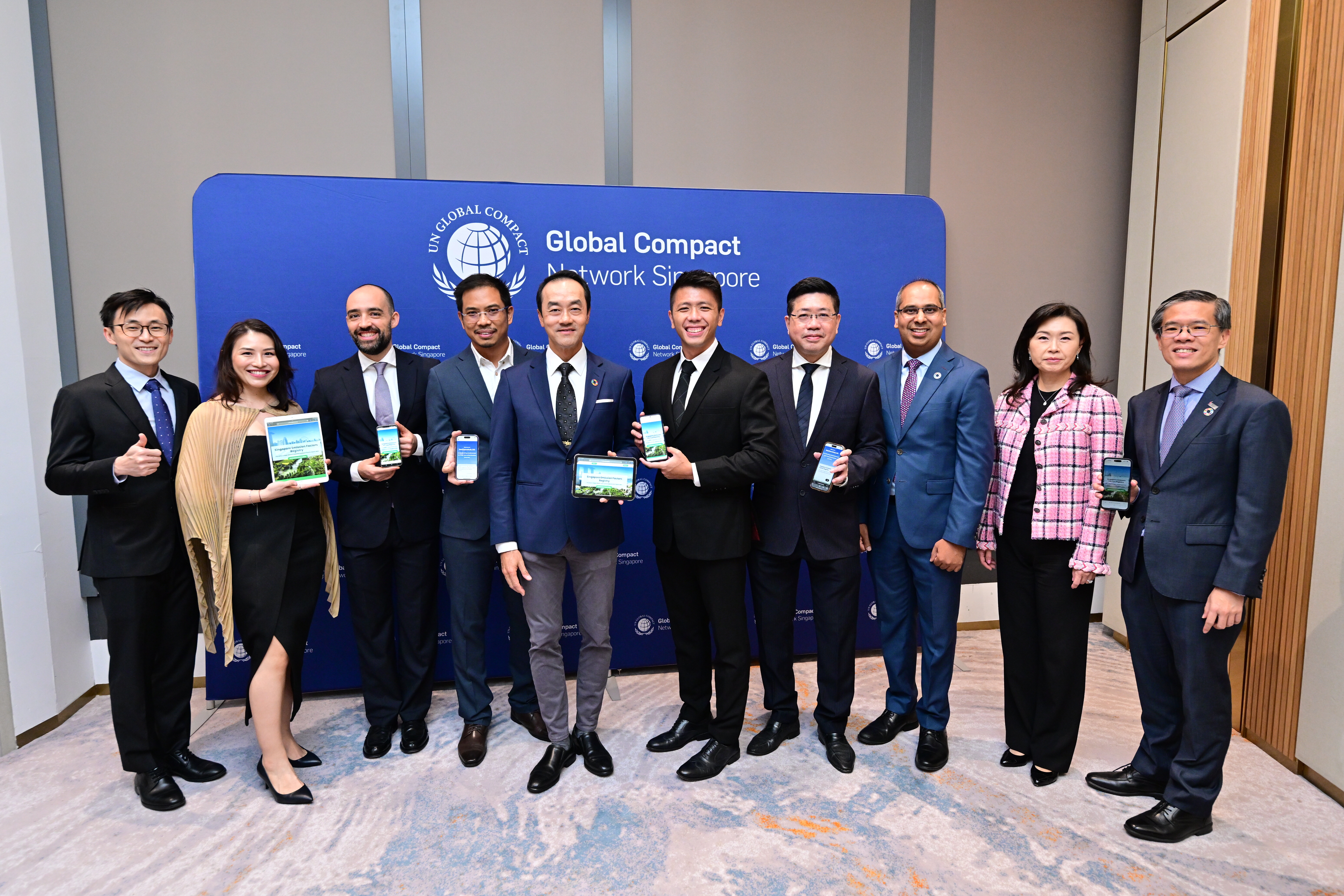 Group of ten partners at the SEFR launch ceremony, smiling and holding the devices showing the Portal.